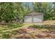 Exterior view of an outbuilding with two rolling garage-style doors and green grass in the yard at 7644 Conrad St, Wesley Chapel, FL 33544