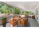 Covered screened porch with seating and dining area; features an expansive view of trees and lush landscape at 7644 Conrad St, Wesley Chapel, FL 33544