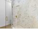 Close-up of a marble shower with a glass door and a rain shower head at 7644 Conrad St, Wesley Chapel, FL 33544