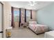 Bright bedroom featuring carpet, a ceiling fan, a bed, two windows, and pink and purple decor at 918 Sombra Street, Tampa, FL 33619