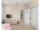 Carpeted bedroom featuring a dresser with TV, a closet, neutral walls, and a view of the house at 918 Sombra Street, Tampa, FL 33619