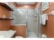 Shower featuring glass doors, tiled walls, and shelving units perfect for storing toiletries at 918 Sombra Street, Tampa, FL 33619