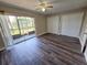 Spacious bedroom with wood-look floors, ceiling fan, and sliding glass door to screened lanai at 9217 Tudor Dr # A106, Tampa, FL 33615