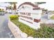 Waterfront community sign surrounded by colorful flowers, creating an inviting entrance at 9217 Tudor Dr # A106, Tampa, FL 33615