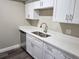 Modern kitchen area with stainless steel sink, quartz countertops, and white cabinetry at 9217 Tudor Dr # A106, Tampa, FL 33615