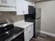 Updated kitchen featuring stainless steel fridge, electric range, and white cabinetry at 9217 Tudor Dr # A106, Tampa, FL 33615