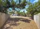 Long backyard features mature trees, and leaf ground cover surrounded by partial fencing for privacy at 922 Alcazar S Way, St Petersburg, FL 33705