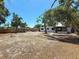 Wide backyard with mature trees, partially fenced, and sandy ground cover perfect for outdoor activities at 922 Alcazar S Way, St Petersburg, FL 33705
