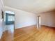 Open living room space with hardwood floors and bright neutral walls, leading to other rooms of the house at 922 Alcazar S Way, St Petersburg, FL 33705