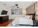 This primary bedroom has a ceiling fan, black and white pictures, wood floors, and a comfortable bed at 109 S Packwood Ave # B, Tampa, FL 33606