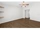 Spacious bedroom featuring wood-look flooring, ceiling fan and three decorative wall shelves at 10900 Livingston Dr, New Port Richey, FL 34654