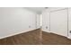 Bedroom features dark wood-look floors, closet, and access to other rooms at 10900 Livingston Dr, New Port Richey, FL 34654