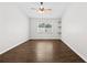 Bedroom with dark wood-look floors, a ceiling fan, and a bright window at 10900 Livingston Dr, New Port Richey, FL 34654