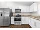 Bright kitchen with stainless steel appliances, granite countertops, and white cabinets at 10900 Livingston Dr, New Port Richey, FL 34654