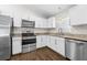 Modern kitchen with stainless steel appliances, granite countertops, and bright white cabinets at 10900 Livingston Dr, New Port Richey, FL 34654