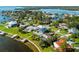 Aerial view of an upscale home with a waterfront backyard, pool, private dock, and manicured lawns at 110 Carlyle Dr, Palm Harbor, FL 34683