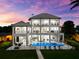 Impressive multi-level home featuring balconies, a pool, an outdoor seating area, and ample outdoor space at 110 Carlyle Dr, Palm Harbor, FL 34683