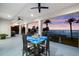 Balcony with chairs and table offers view of palm trees and waterfront at sunset at 110 Carlyle Dr, Palm Harbor, FL 34683