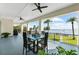 Balcony table and chairs overlook the waterfront and palm trees under blue skies at 110 Carlyle Dr, Palm Harbor, FL 34683