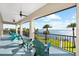 Balcony with rocking chairs overlooking a waterfront view with tropical palm trees at 110 Carlyle Dr, Palm Harbor, FL 34683
