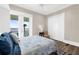 Bright bedroom featuring wood flooring, a side table, and balcony access with scenic views at 110 Carlyle Dr, Palm Harbor, FL 34683