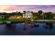 Elegant waterfront home featuring a boat dock, lush green lawn, and stylish exterior design at 110 Carlyle Dr, Palm Harbor, FL 34683