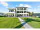 View of a luxurious waterfront home showcasing its sprawling lawn and outdoor living spaces at 110 Carlyle Dr, Palm Harbor, FL 34683