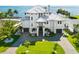 View of waterfront property featuring a white exterior, manicured lawn, and metal roof at 110 Carlyle Dr, Palm Harbor, FL 34683