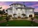 Beautiful three-story home featuring meticulously landscaped grounds, a three-car garage, and central entry at 110 Carlyle Dr, Palm Harbor, FL 34683