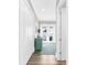 Bright hallway leading to a balcony with views, featuring wood floors and white trim at 110 Carlyle Dr, Palm Harbor, FL 34683