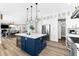 Open kitchen with white cabinetry, stainless steel appliances, and blue island at 110 Carlyle Dr, Palm Harbor, FL 34683