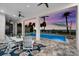 Covered patio with dining table and chairs offering views of the pool, ocean, and palm trees at 110 Carlyle Dr, Palm Harbor, FL 34683