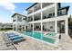 Expansive backyard with a pristine pool, hot tub, and a multi-story home with balconies at 110 Carlyle Dr, Palm Harbor, FL 34683