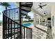 Backyard view of a luxurious pool and deck area with a spiral staircase leading to upper level balconies at 110 Carlyle Dr, Palm Harbor, FL 34683