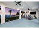 Covered porch offering stunning water and sunset views with outdoor dining and living space at 110 Carlyle Dr, Palm Harbor, FL 34683
