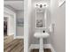 Chic powder room featuring a pedestal sink, decorative mirror, and neutral color palette at 110 Carlyle Dr, Palm Harbor, FL 34683