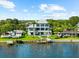 Elegant waterfront estate featuring a manicured lawn, pool, and private dock for boating and water activities at 110 Carlyle Dr, Palm Harbor, FL 34683