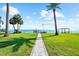 Waterfront property featuring a lush green lawn leading to a private dock and a picturesque view at 110 Carlyle Dr, Palm Harbor, FL 34683