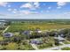 Aerial view of the property showcasing surrounding homes, lush greenery, and expansive open fields at 1110 Canal St, Ruskin, FL 33570