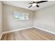 A cozy bedroom featuring wood floors, ceiling fan, and natural light streaming through the windows at 1110 Canal St, Ruskin, FL 33570