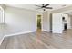 Spacious bedroom view into bright bathroom and kitchen, complemented by sleek wood-look floors at 1110 Canal St, Ruskin, FL 33570