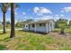 Side view of a cozy home showcasing a covered patio and lush green lawn, ideal for outdoor living at 1110 Canal St, Ruskin, FL 33570