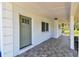 Welcoming covered porch with tile flooring, a charming green door, and bright natural light at 1110 Canal St, Ruskin, FL 33570