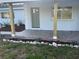 Inviting front porch with new tile, natural wood posts and rock flower bed at 1110 Canal St, Ruskin, FL 33570