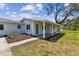 Inviting front porch with tiled flooring, decorative landscaping, and a welcoming green front door at 1110 Canal St, Ruskin, FL 33570