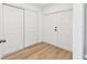 Hallway featuring two interior doors and light wood floors at 1110 Canal St, Ruskin, FL 33570