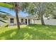 Beautiful home backyard with lush green lawn, shade trees, patio, and outdoor seating at 11728 Crest Creek Dr, Riverview, FL 33569