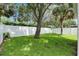 Backyard featuring a lush lawn, large shade trees, and a white vinyl privacy fence at 11728 Crest Creek Dr, Riverview, FL 33569
