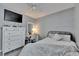 This bedroom features a white dresser and desk, a TV, and a comfortable bed at 11728 Crest Creek Dr, Riverview, FL 33569