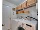 Bright laundry room with white appliances and plenty of storage baskets above at 11728 Crest Creek Dr, Riverview, FL 33569